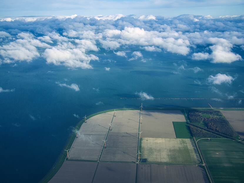 Een veld met windmolens van bovenaf.